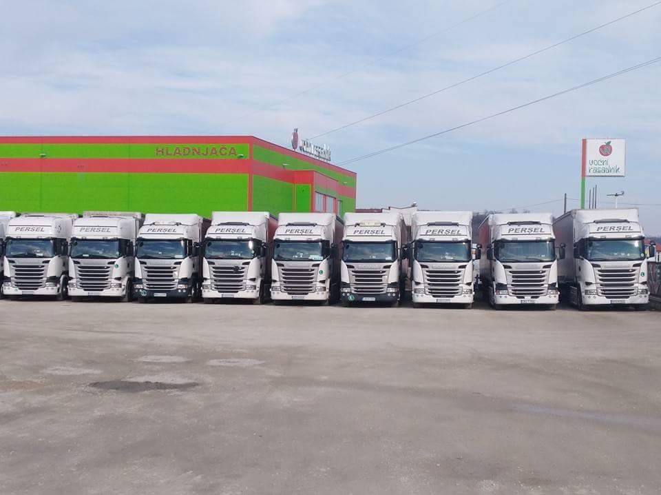 Red bijelih Scania kamiona Persel Transport poredanih ispred hladnjače — panoramski pogled na vozni park