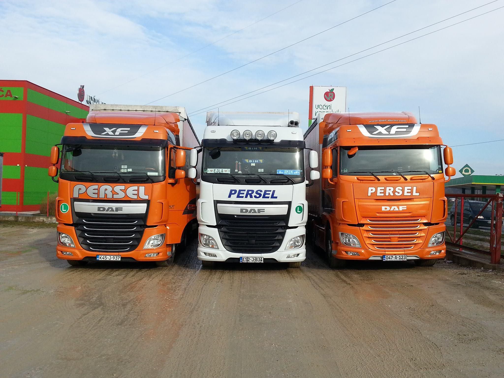 Tri DAF XF kamiona Persel Transport — dva narandžasta i jedan bijeli — ispred baze u Špionici